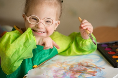 child with special needs playing with paint