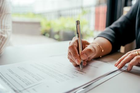 person signing a document in an office